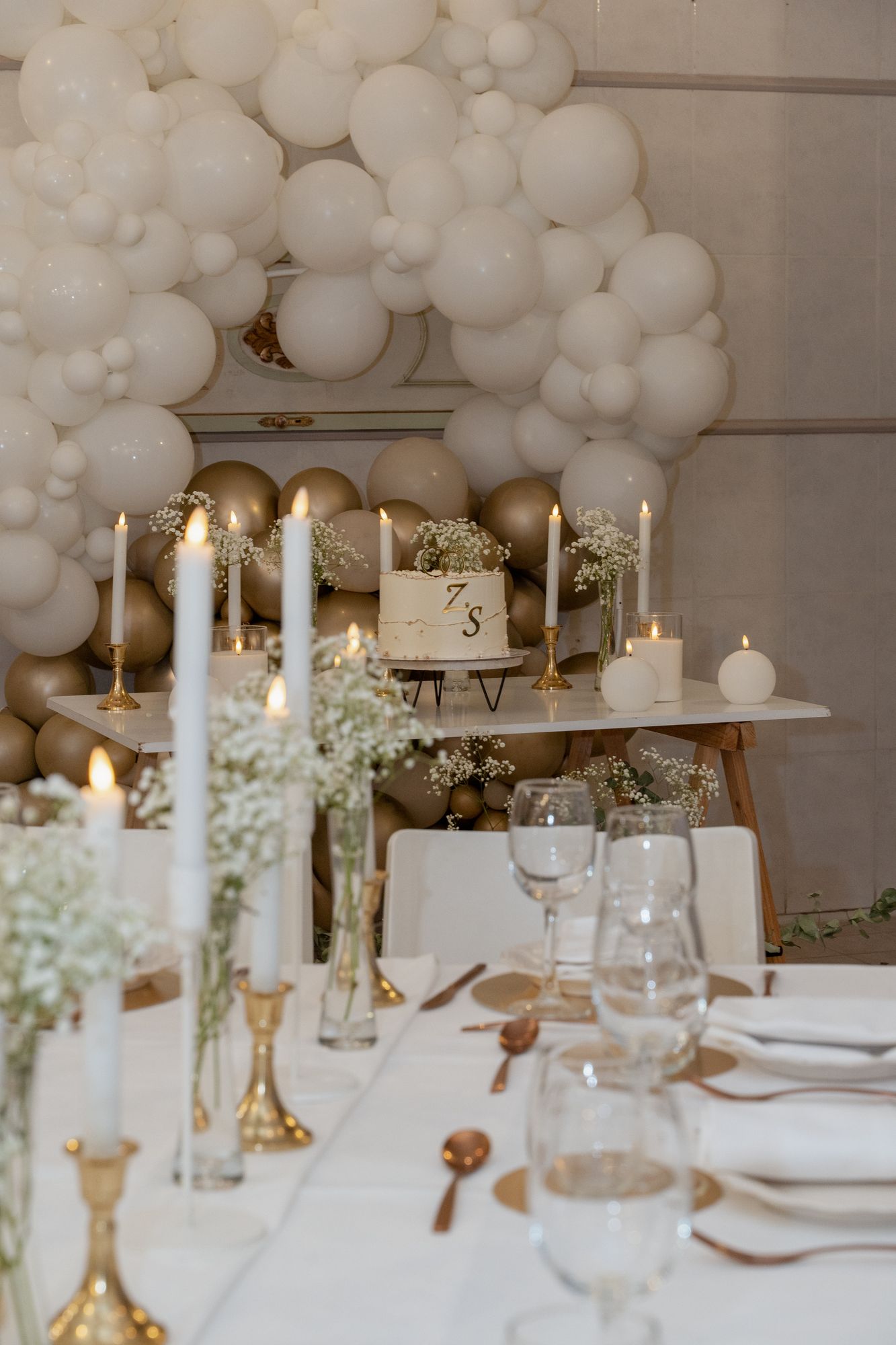Mesa de los novios con velas y globos blancos