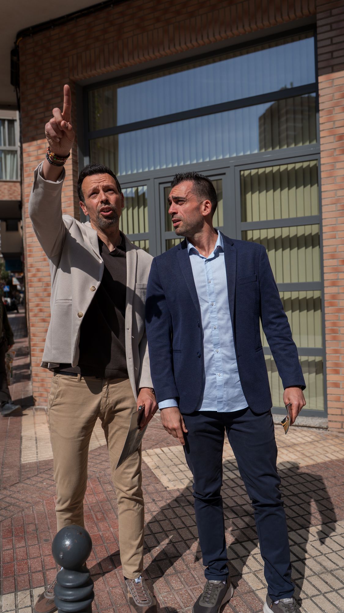 Dos agentes señalando un edificio en la calle