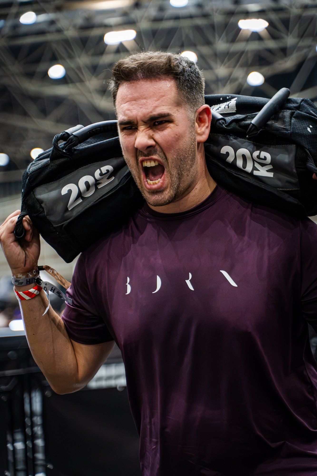 Atleta gritando con un saco de 20 kg al hombro