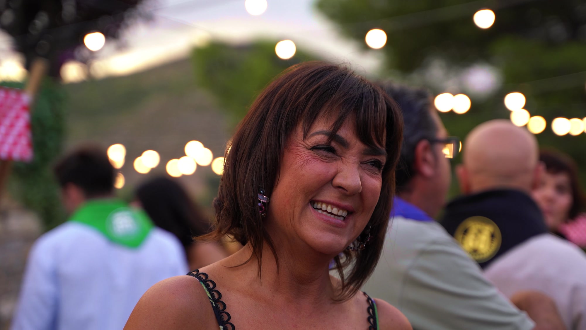 Inma sonriendo bajo las guirnaldas de luces